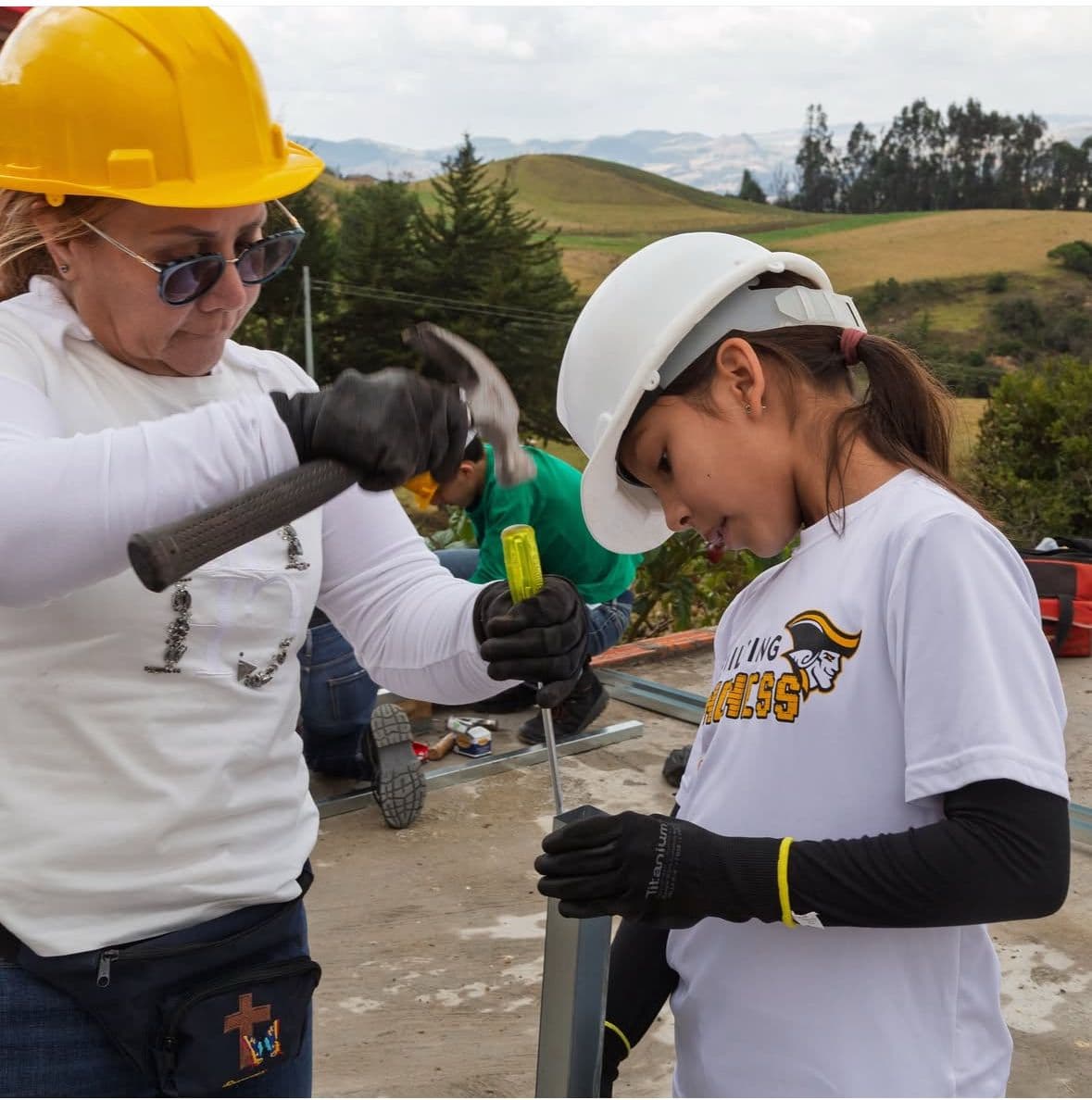 An adult and a young volunteer hammering together during a build