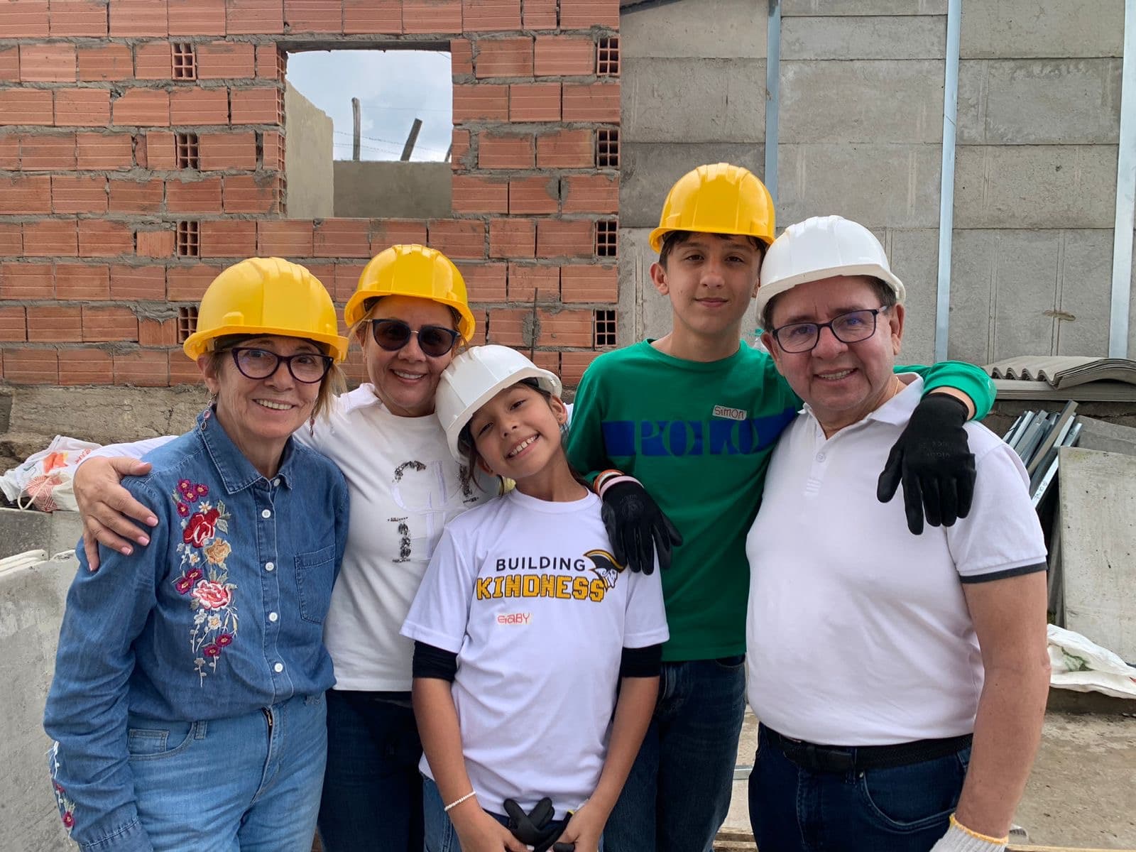 Volunteers posing together in hard hats during a home build in Colombia